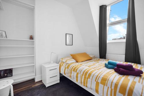 a white bedroom with a bed and a window at Modern Spacious Rooms 10 Minutes from Big Ben in London