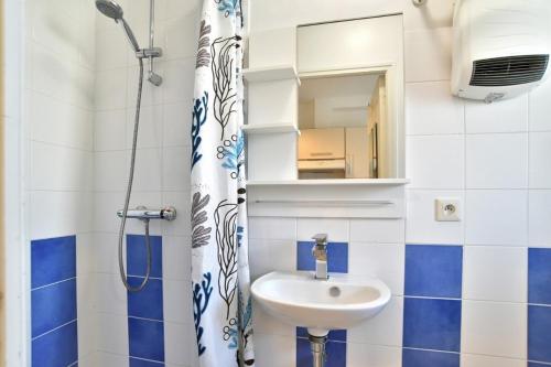 une salle de bain avec un lavabo et un rideau de douche dans l'établissement Maison de charme dans rue très calme, à Saint-Malo