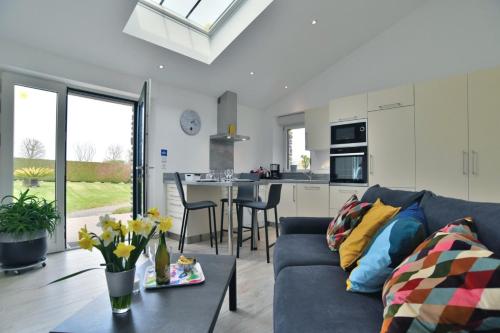 un salon avec un canapé bleu et une cuisine dans l'établissement Gîte Radegonde, à Saint-Méloir-des-Ondes