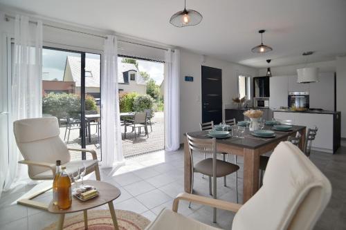 une cuisine et un salon avec une table et des chaises dans l'établissement Lescale des douets fleuris, à Cancale