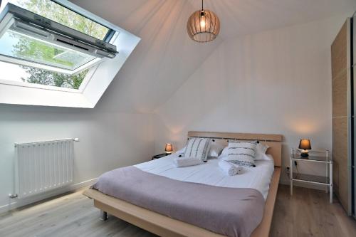 une chambre avec un lit avec des oreillers et une fenêtre dans l'établissement Lescale des douets fleuris, à Cancale