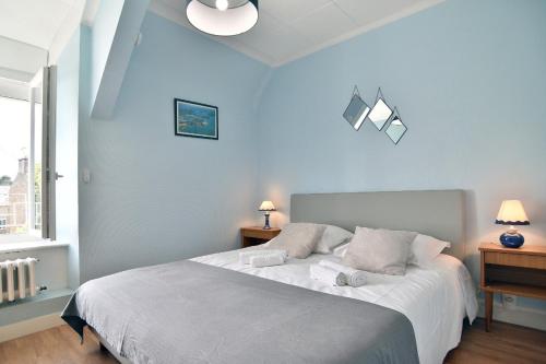 une chambre avec un grand lit aux murs bleus dans l'établissement Larmoricaine, à Cancale