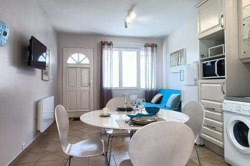 a kitchen and dining room with a table and chairs at Le petit chalet bleu in Cancale