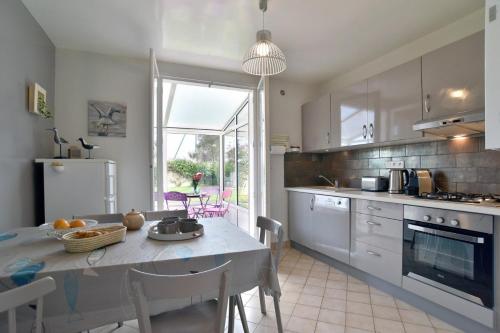 une cuisine avec une table et une salle à manger dans l'établissement Karome, à Saint-Coulomb