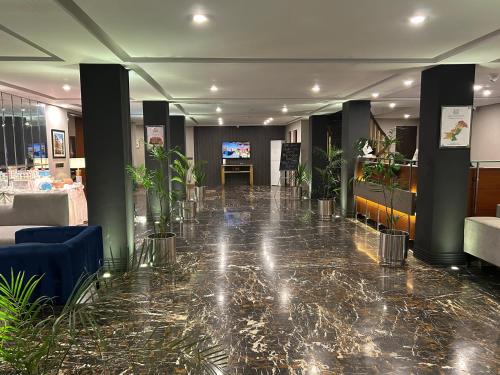 a lobby with potted plants and a tv in it at Hotel One The Mall, Lahore in Lahore