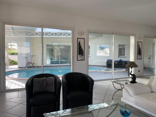 - un salon avec un canapé et des chaises ainsi qu'une piscine dans l'établissement Ghiso, à Ghisonaccia