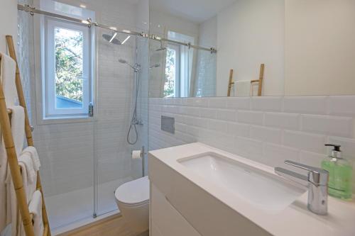 a white bathroom with a sink and a shower at Uporto House Palace in Porto