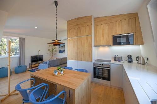 a kitchen with a wooden table and blue chairs at Uporto House Palace in Porto