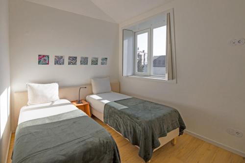 a room with two beds and a window at Uporto House Palace in Porto