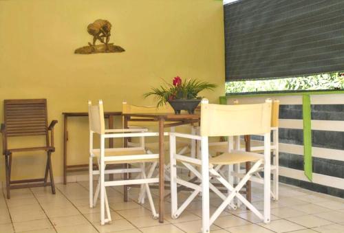 a dining room with a table and chairs at Bungalow charmant à Sainte-Rose avec piscine partagée in Sainte-Rose