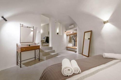 a bedroom with a bed and a dresser and a mirror at Caveart Villa & Prive Terrace with Prive Jacuzzi in Santorini