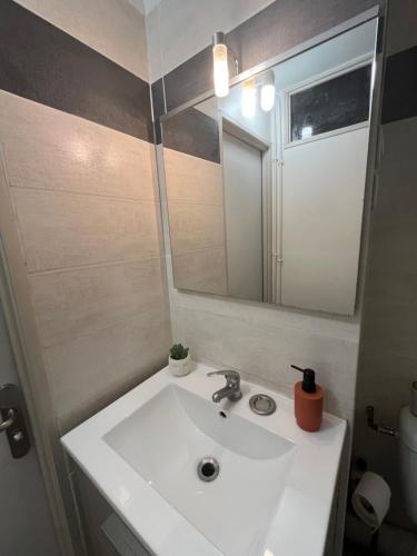 une salle de bain avec un lavabo blanc et un miroir dans l'établissement Cocon Cosy Gare St Roch, à Montpellier