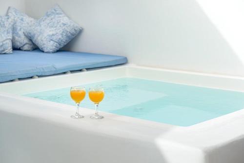 two glasses of orange juice sitting on a bath tub at Caveart Villa & Prive Terrace with Prive Jacuzzi in Santorini