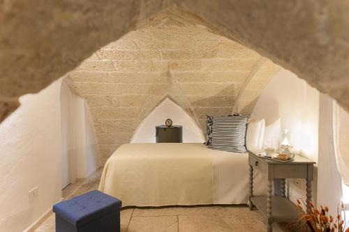 ein Schlafzimmer mit einem Bett in einer Steinmauer in der Unterkunft Le Antiche Volte in Fasano