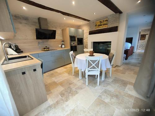 Il comprend une cuisine avec une table et des chaises. dans l'établissement Gite de la Forge, à Longueville