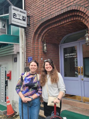 two women standing in front of a brick building at Son-Gil Guesthouse in Jinju