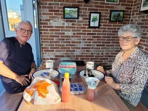 an older man and woman sitting at a table at Son-Gil Guesthouse in Jinju