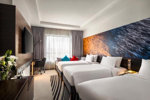 a row of beds in a hotel room at Novotel Makkah Thakher City in Makkah