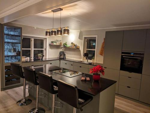 una cucina con ampia isola con sedie da bar di Villa Borealis a Trondalen