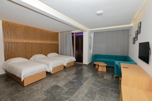a hotel room with two beds and a couch at Sahara Beach in Tan-Tan Plage