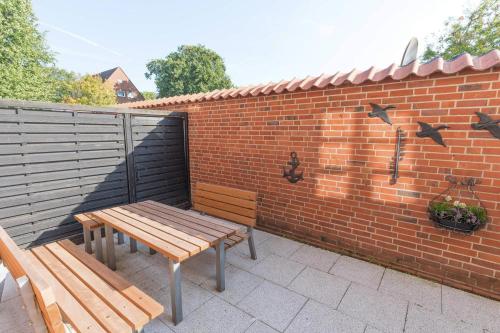 a patio with two benches and a brick wall at Lütte Stuuv im Schlossgang in Husum