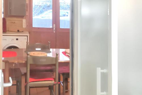a kitchen with a table and a table and chairs at Chalet charmant à Poussan avec jardin privé et barbecue in Poussan