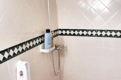 a bathroom with a shower with a blue bottle on the wall at Welcoming house in Souto da Casa - 50 m² with enclosed garden in Souto da Casa