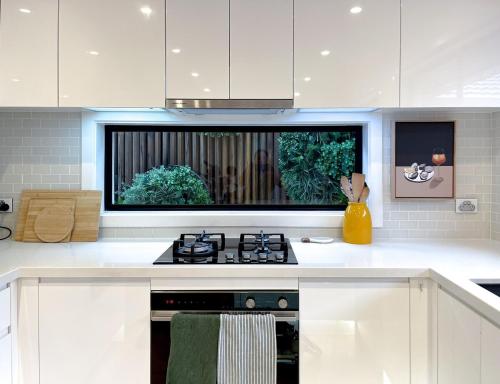 a kitchen with a stove and a tv on the wall at Bayside Retreat near beach and Frankston centre in Frankston