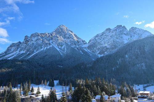 a mountain range with trees and snow covered mountains at DZ Komfort in Biberwier