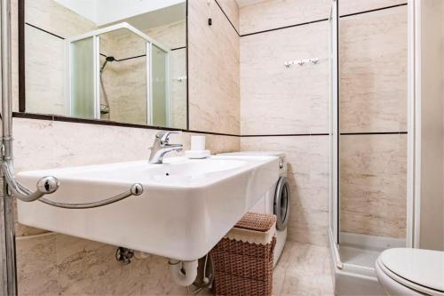 a white bathroom with a sink and a shower at Appartamento Vista Mare - Spriano in Rio Marina