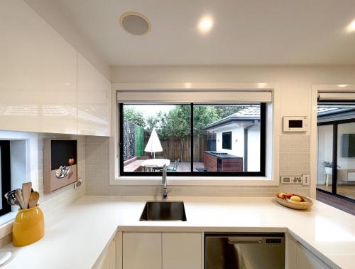 a kitchen with a sink and a large window at Bayside Retreat near beach and Frankston centre in Frankston