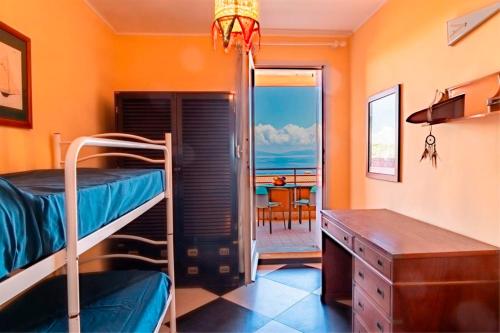 a room with bunk beds and a desk and a table at Appartamento Vista Mare - Spriano in Rio Marina