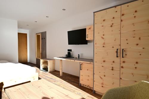 a bedroom with a bed and a desk and a tv at DZ Komfort in Biberwier