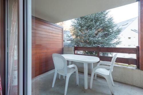 a white table and two chairs on a balcony at T2 avec piscine couverte et parking in Saint-Lary-Soulan