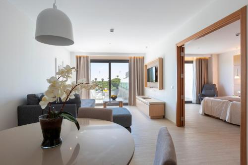 a living room with a couch and a table in a room at Hipotels Barrosa Park in Chiclana de la Frontera