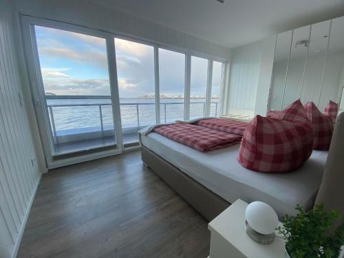 a bedroom with a bed with a view of the ocean at Antares One by Seeblick Ferien in Olpenitz