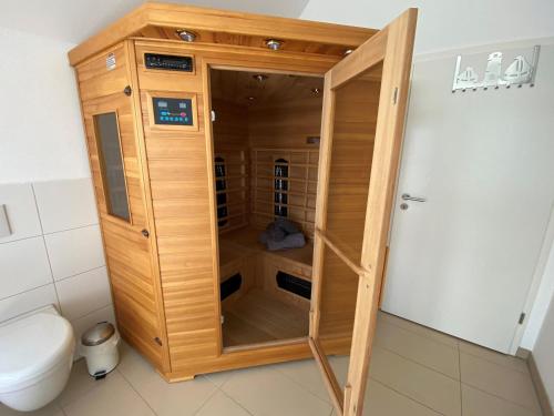 オルペニッツにあるKapteins Lounge by Seeblick Ferienのトイレの隣のバスルームにある木製キャビネット