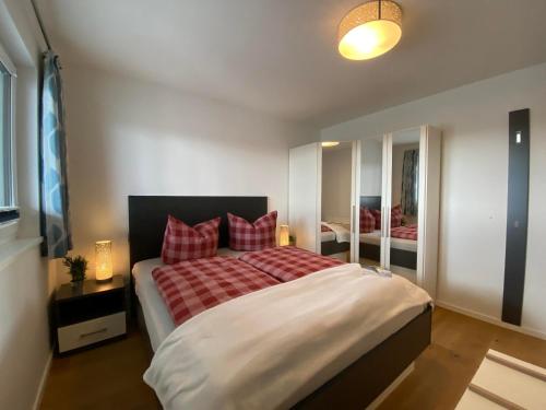 a bedroom with a large bed with red pillows at Reeders Nest by Seeblick Ferien in Olpenitz