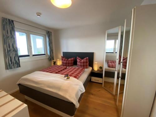 Un dormitorio con una cama y dos ventanas. en Reeders Nest by Seeblick Ferien, en Olpenitz