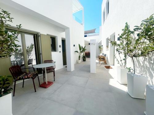 an outdoor patio with a table and chairs and plants at Naousa Paros Suite B with private jacuzzi in Naousa