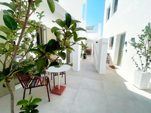 a courtyard with plants and a table and chairs at Naousa Paros Suite B with private jacuzzi in Naousa