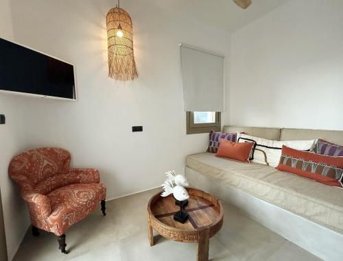 a living room with a couch and a chair at Naousa Paros Suite B with private jacuzzi in Naousa