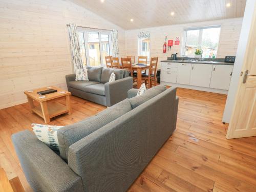 a living room with a couch and a table at Dovestone Secluded Luxury Lodges sleeps 6 - pets welcome in Oldham