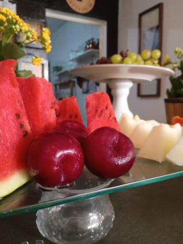 a plate of fruit on top of a table at Pousada Casa Jardim in Serra Negra