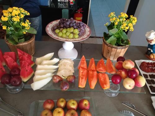 a table with a bunch of fruits and vegetables at Pousada Casa Jardim in Serra Negra