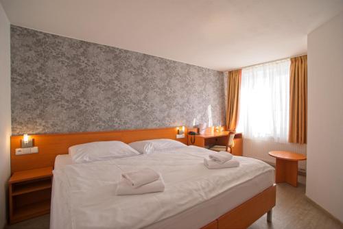 Postel nebo postele na pokoji v ubytování Wine Wellness Hotel Amande Hustopeče
