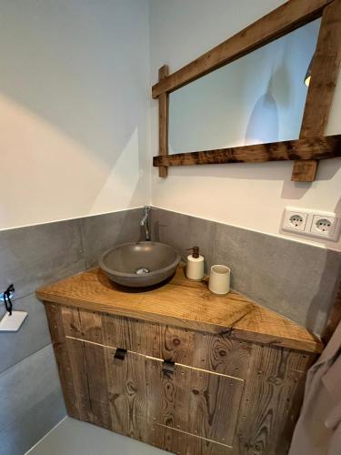 a bathroom with a wooden vanity with a sink at Hello Noordwijk - Studio Pietheinplein 1 in Noordwijk aan Zee