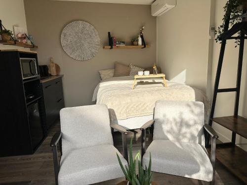 a bedroom with a bed with two chairs and a table at Hello Noordwijk - Studio Pietheinplein 1 in Noordwijk aan Zee