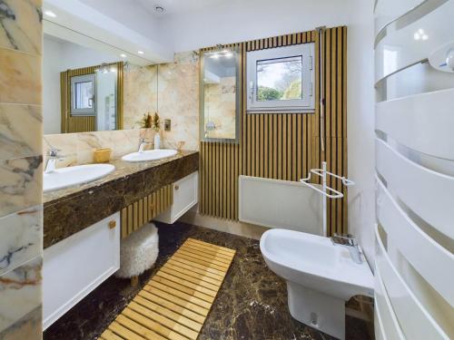 a bathroom with two sinks and two mirrors at Grande maison spacieuse et moderne avec jardin in Fouesnant