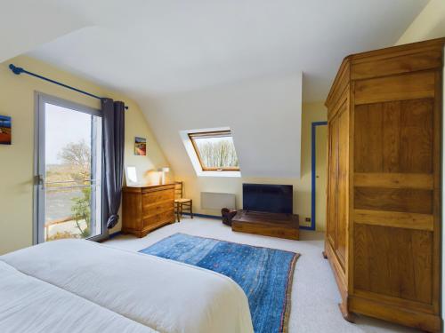 a bedroom with a large bed and a large window at Grande maison spacieuse et moderne avec jardin in Fouesnant